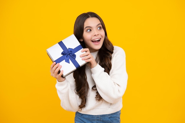 Enfant avec coffret cadeau sur fond de studio isolé Cadeaux pour enfants anniversaire Surpris adolescente