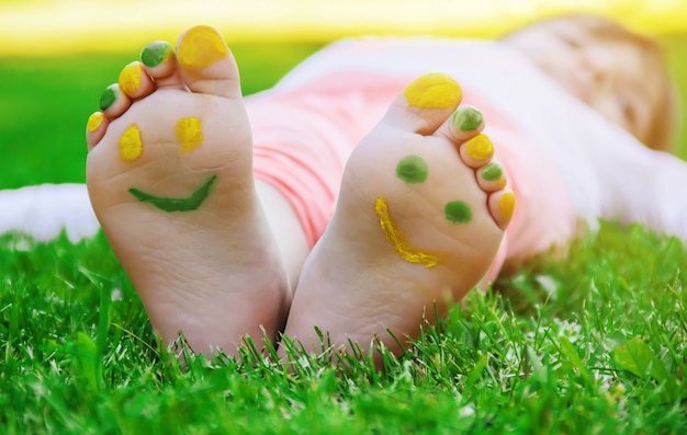 Photo enfant couché sur l'herbe verte. kid s'amuser en plein air dans le parc du printemps.