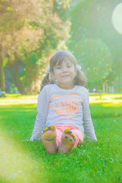 Enfant couché sur l&#39;herbe verte. Kid s&#39;amuser en plein air dans le parc du printemps.