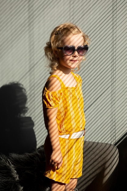 Enfant de coup moyen avec des lunettes de soleil