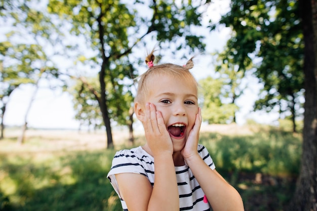 Un enfant crie de bonheur et de surprise dans un parc d'été à l'extérieur Moments heureux