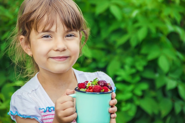 L&#39;enfant cueille des cerises dans le jardin. Mise au point sélective.