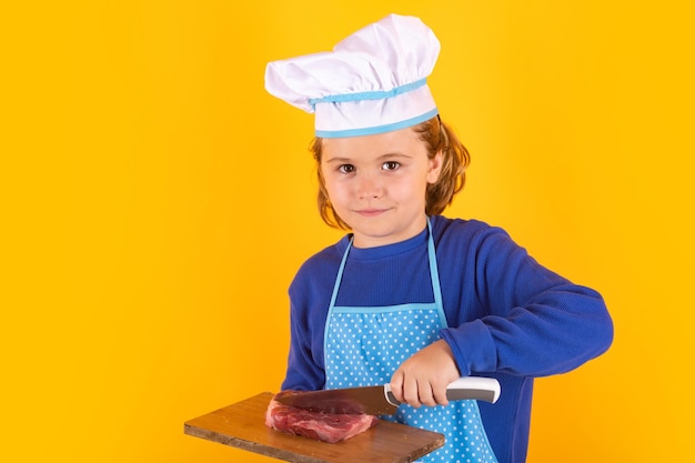 Enfant cuisinier tenir une planche à découper avec du steak de boeuf à la viande et un couteau