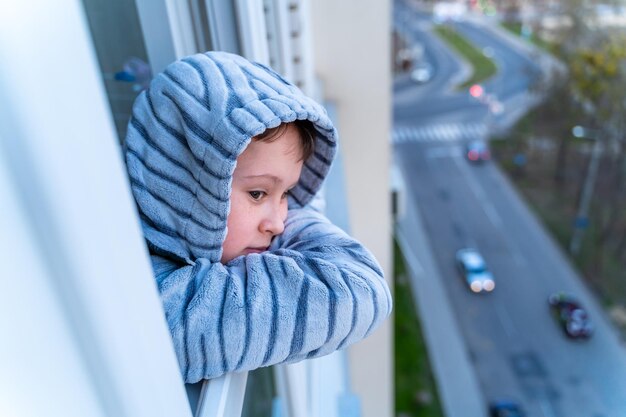 Un enfant curieux regardant à travers le verre Un petit garçon regardant par une fenêtre