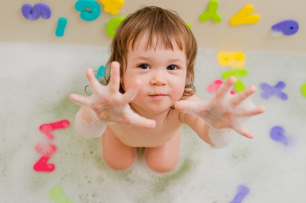 Enfant dans un bain avec de la mousse