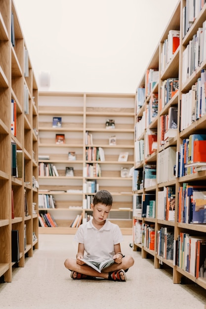 Enfant dans la bibliothèque de l'école. Les enfants lisent des livres. Petit garçon lisant et étudiant. Enfants à la librairie. Enfant d'âge préscolaire intelligent et intelligent choisissant des livres à emprunter.