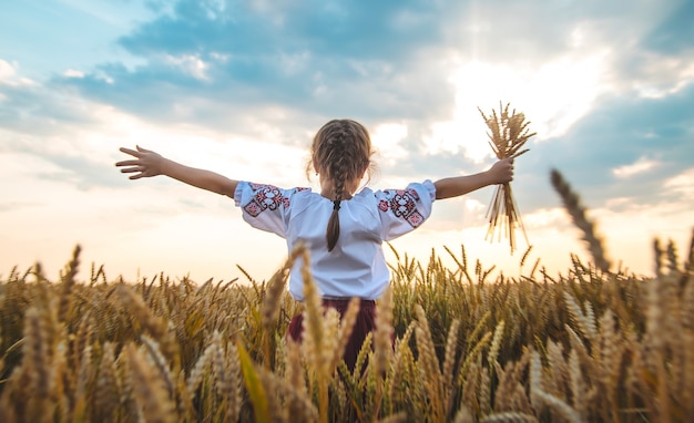 Enfant dans un champ de blé. Dans vyshyvanka, le concept de la fête de l'indépendance de l'Ukraine. Mise au point sélective. Enfant.