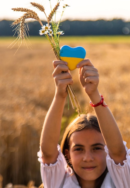 Enfant dans un champ de blé avec le drapeau de l'Ukraine Mise au point sélective Nature