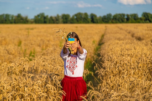 Enfant dans un champ de blé avec le drapeau de l'Ukraine Mise au point sélective Nature