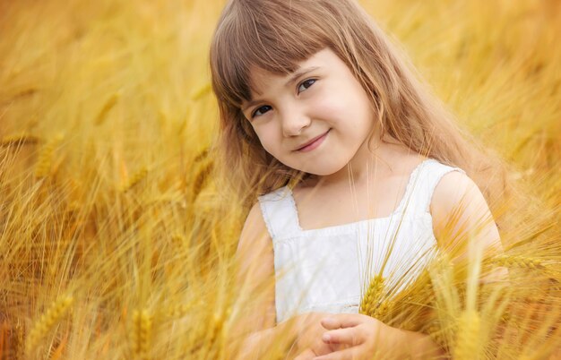 Enfant dans un champ de blé. mise au point sélective. la nature