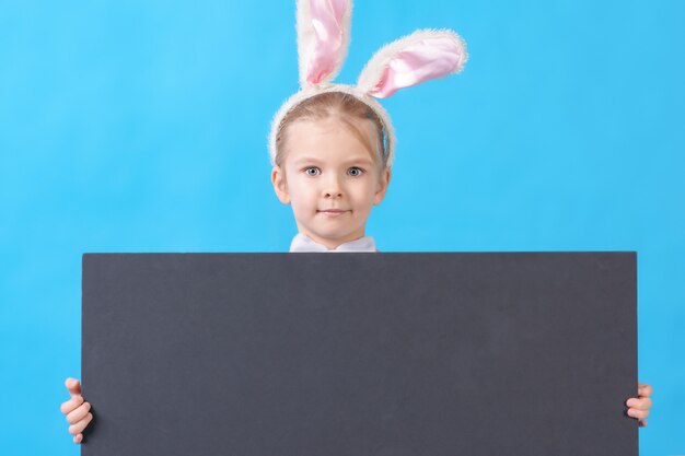 Un enfant dans un costume de lapin blanc sur bleu