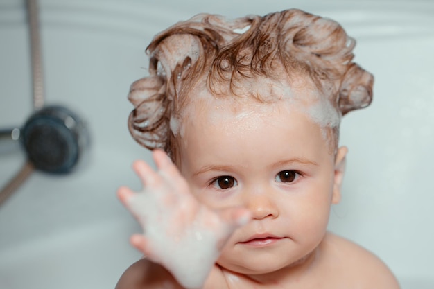 Enfant dans la douche drôle bébé enfant baigné dans de la mousse et se lavant dans la baignoire à la maison enfant dans la baignoire avec la grippe