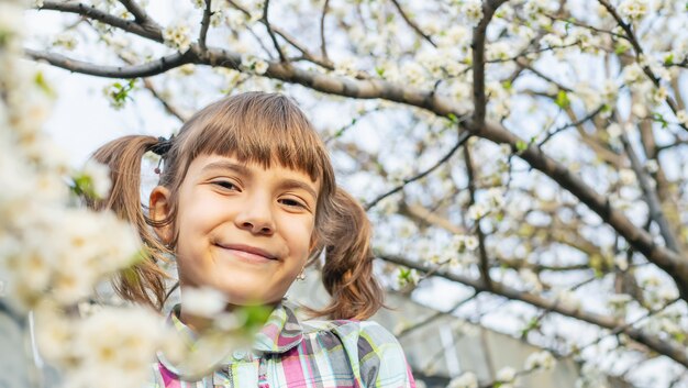 Un enfant dans le jardin d'arbres en fleurs. Mise au point sélective.