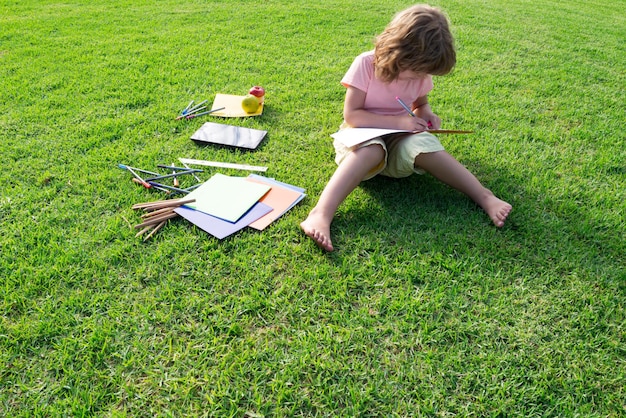 Photo enfant dans le parc lisant pour l'éducation à la maison en dehors de l'apprentissage