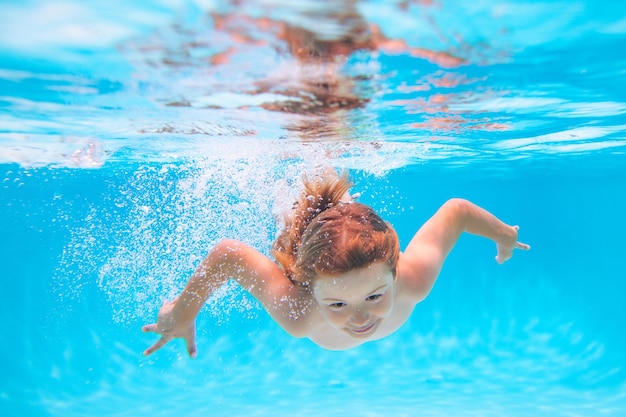 Enfant dans la piscine en été jour enfant nageant sous l'eau dans la piscine drôle enfants garçon jouer et nager