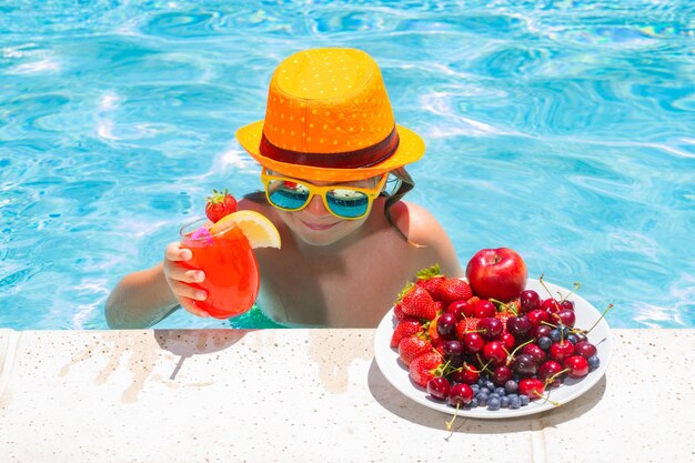 Enfant dans la piscine avec des fruits Activité pour les enfants d'été Vacances d'été Mode de vie sain pour les enfants