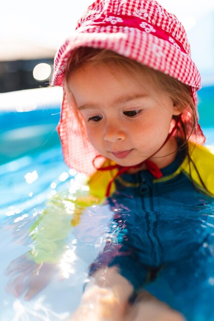 Photo enfant dans une piscine gonflable dans l'arrière-cour protection solaire appropriée pour les bébés concept