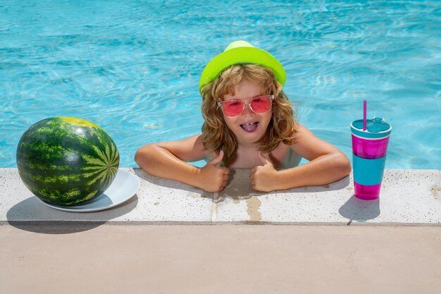 Enfant dans la piscine avec pastèque Activité de plein air saine pour les enfants Amusement de plage pour enfants Mode été enfants en chapeau et lunettes de soleil roses Cocktail d'été pour les enfants