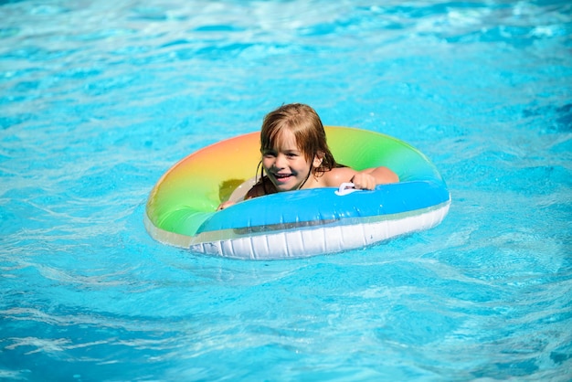 Enfant dans la piscine se détendre nager sur un anneau gonflable et s'amuser dans l'eau pendant les vacances d'été Mode de vie sain des enfants