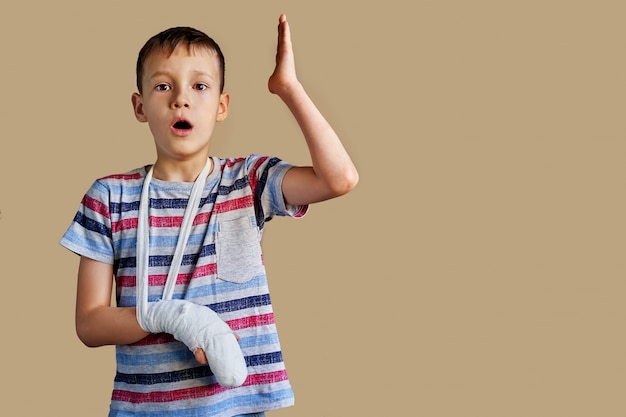 Un enfant dans un t-shirt rayé avec un bandage enroulé autour de son bras