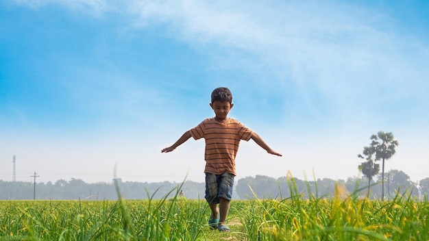 Photo un enfant danse avec la nature sur un sentier rural des enfants d'un village du bangladesh jouent dans le champ