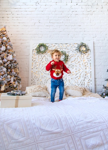 Un enfant danse près d'un sapin de Noël Mise au point sélective