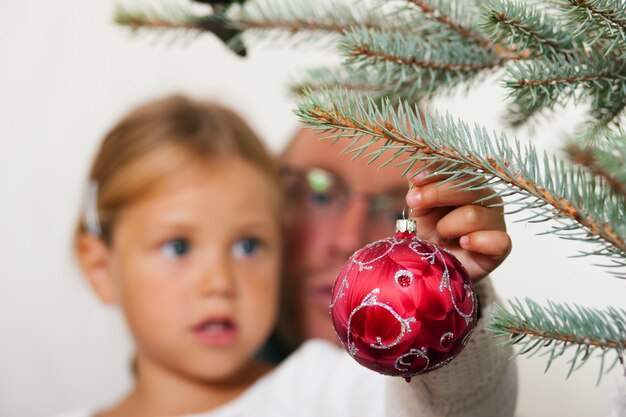 Enfant décorant le sapin de Noël