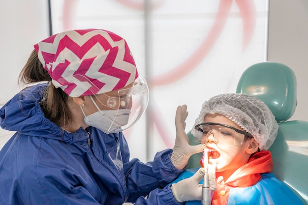 Un enfant avec un dentiste dans un cabinet dentaire. Traitement dentaire dans une clinique pour enfants.