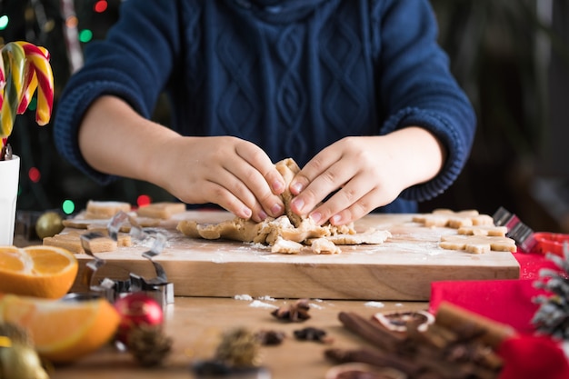 Enfant déployant la pâte pour les biscuits de Noël