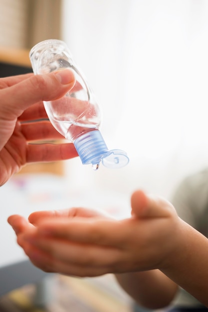 Enfant désinfectant les mains avec un désinfectant pour les mains