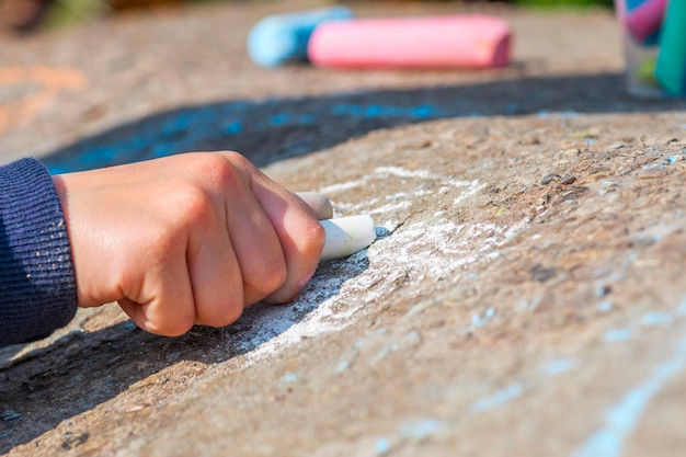 L'enfant dessine une craie sur l'asphalte