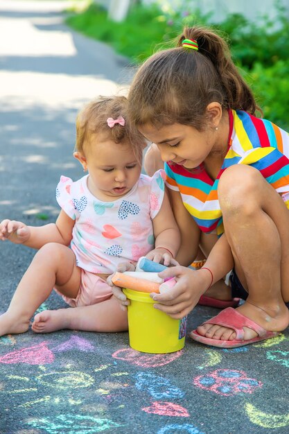 L'enfant dessine à la craie sur l'asphalte