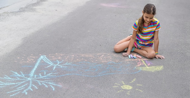 L'enfant dessine à la craie sur le trottoir Mise au point sélective