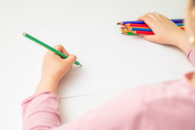 Photo l'enfant dessine avec des crayons de couleur.