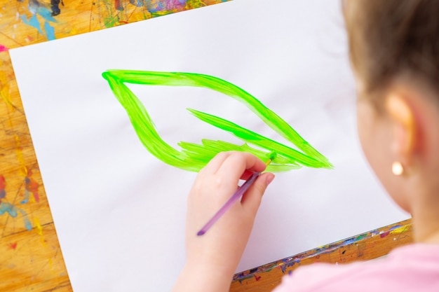 Photo l'enfant dessine une feuille verte