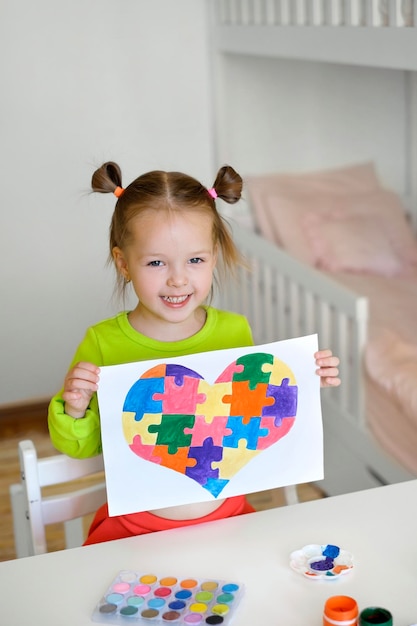 Un enfant a dessiné une image d'un cœur à partir de puzzles comme cadeau à un ami souffrant d'autisme