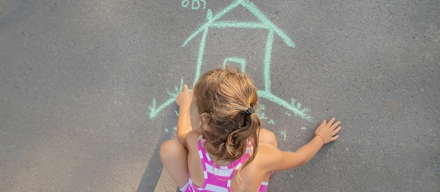 L'enfant dessine une maison de craie Mise au point sélective