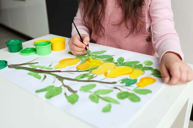 L'enfant dessine avec des peintures le concept d'une leçon pour enfants