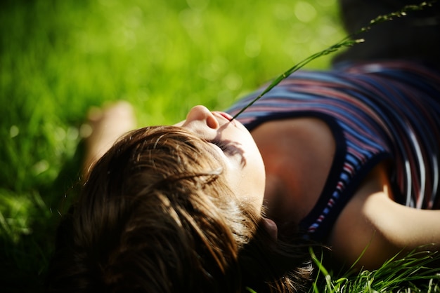 Enfant détendu reposant sur la prairie d&#39;herbe parc d&#39;été