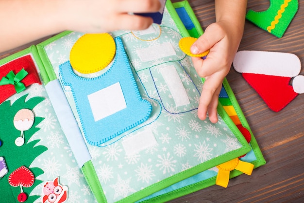 L'enfant développe sa motricité fine à l'aide d'un livre en développement