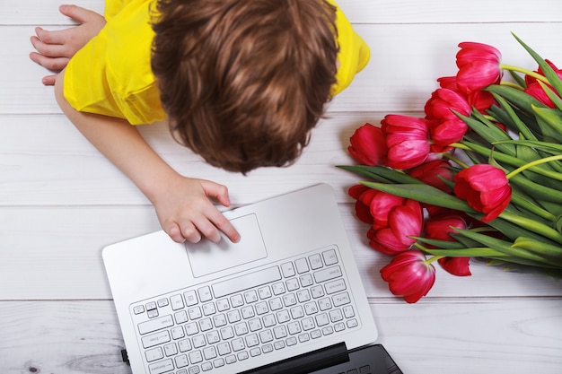 Enfant Discutant Sur Un Carnet Avec Des Tulipes à Bouquet Pour Sa Mère.