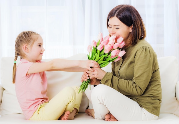 Enfant donnant un bouquet de fleurs le jour de la fête des mères