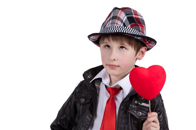 Enfant drôle dans une cravate rouge et un chapeau tient une baguette avec un coeur Garçon avec une Saint-Valentin