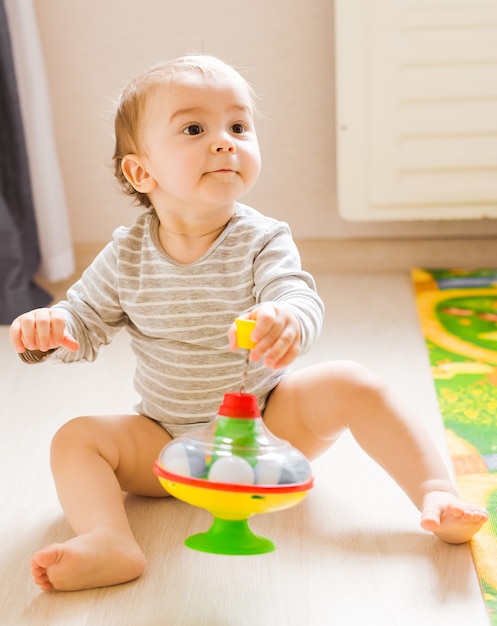 Photo enfant drôle de petit garçon jouant avec le jouet