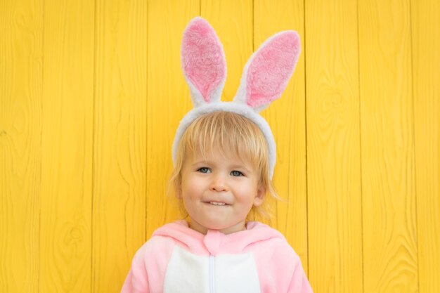 Enfant drôle portant le lapin de Pâques. Enfant s'amusant à la maison.