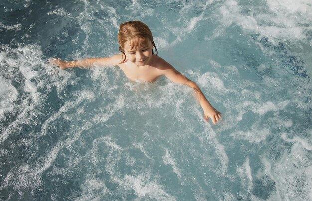 Enfant drôle profitant de l'été dans la piscine. Spa bain à remous.