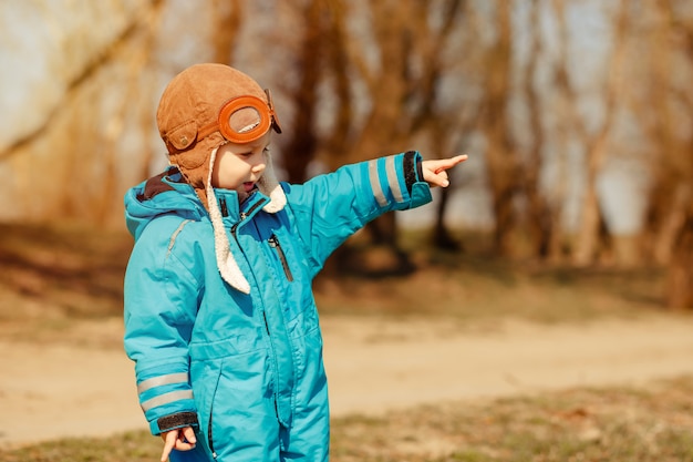 Enfant drôle sur la promenade dans la forêt ensoleillée. Concept d'enfance heureuse