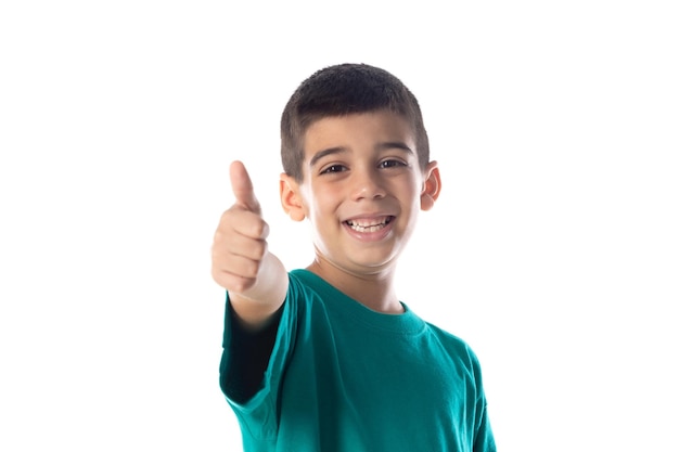 Enfant drôle avec Tshirt vert disant Ok et isolé sur fond blanc