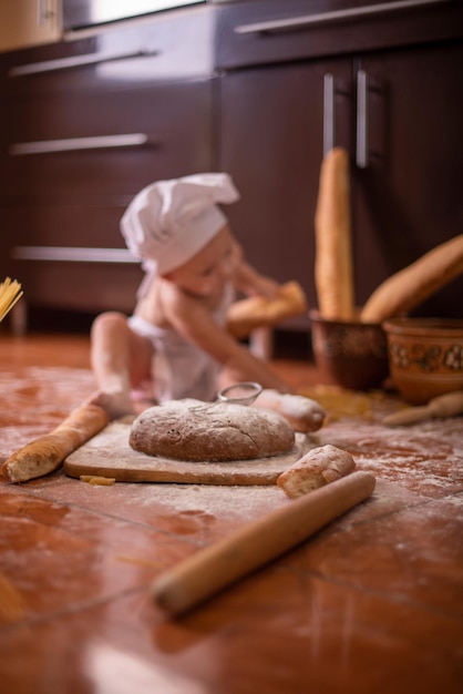 enfant avec du pain dans les mains habillé en cuisinier