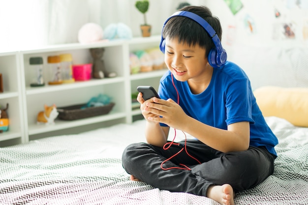 Enfant écoutant de la musique sur le lit dans la chambre pour se détendre